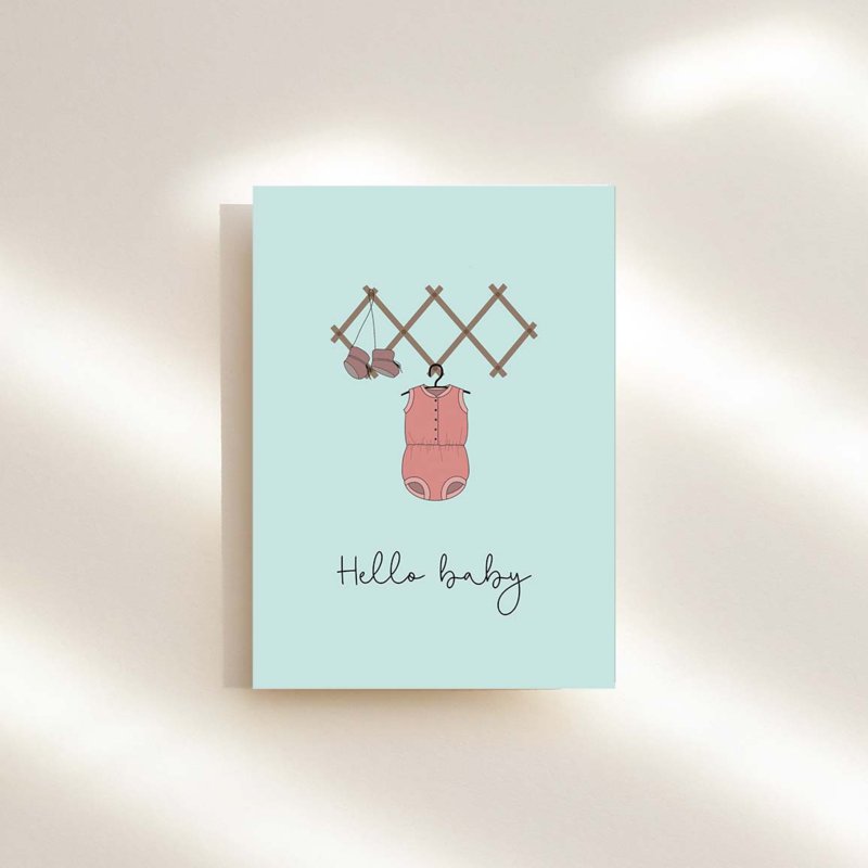 Wenskaart voor de geboorte van een meisje met roze kruippakje en hello baby